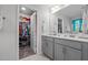 Bathroom features gray vanity with dual sinks and an open door to a walk-in closet at 308 Thorndale Dr, Dunn, NC 28334