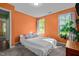 Sunlit bedroom with orange walls, two windows offering views, a comfortable bed, and modern decor at 308 Thorndale Dr, Dunn, NC 28334