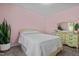 Cozy bedroom featuring a bed, snake plant, nightstand, dresser, mirror, carpet, and soft pink walls at 308 Thorndale Dr, Dunn, NC 28334