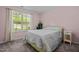 Cozy bedroom with a comfortable bed, neutral carpet, a window letting in light, and a decorative snake plant at 308 Thorndale Dr, Dunn, NC 28334