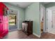 Inviting entryway with a bright red door and a lovely wooden accent table upon a backdrop of light green walls and dark floors at 308 Thorndale Dr, Dunn, NC 28334