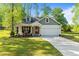 Charming home with a well-maintained lawn, a front porch seating area, and an attached two-car garage at 308 Thorndale Dr, Dunn, NC 28334