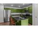 Modern kitchen featuring granite countertops, stainless steel appliances, an island with breakfast bar, and green cabinets at 308 Thorndale Dr, Dunn, NC 28334