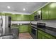 Kitchen boasting stainless appliances, granite counter tops, island with sink, and contemporary green cabinets at 308 Thorndale Dr, Dunn, NC 28334