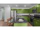 Kitchen featuring stainless steel appliances, modern island with barstool seating, and bright green cabinetry at 308 Thorndale Dr, Dunn, NC 28334
