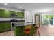 Bright kitchen features modern appliances, green cabinetry and a center island with granite countertops at 308 Thorndale Dr, Dunn, NC 28334