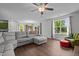Bright living room with a comfy gray couch, hardwood floors, natural light, and a ceiling fan at 308 Thorndale Dr, Dunn, NC 28334