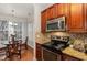 Kitchen with stainless appliances, dark wood cabinets and adjacent dining area at 311 Providence Glen Dr, Chapel Hill, NC 27514