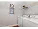 This laundry room has wood floors, a clock on the wall, and a white washer and dryer set at 311 Providence Glen Dr, Chapel Hill, NC 27514