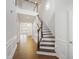 Bright entryway with wood floors, staircase with wood and white accents, and open floorplan at 317 Castle Rock Ln, Cary, NC 27519