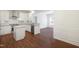 Open-concept kitchen with white cabinetry, granite countertops, stainless steel appliances, and wood flooring at 317 Castle Rock Ln, Cary, NC 27519