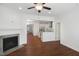 Open-concept living area featuring a fireplace, wood floors, and seamless access to the modern kitchen at 317 Castle Rock Ln, Cary, NC 27519