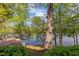 Picturesque lake view framed by lush trees and vibrant azaleas, offering a tranquil backyard escape at 373 & 375 Sagamore Dr, Louisburg, NC 27549