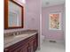 Bathroom featuring wood cabinets, granite counters, framed mirror, and tiled floors at 373 & 375 Sagamore Dr, Louisburg, NC 27549