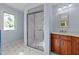 Bright bathroom with large glass shower, wood vanity, marble counters, and a stained glass window at 373 & 375 Sagamore Dr, Louisburg, NC 27549