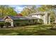 Well-manicured lawn surrounds a light green home, complemented by lush trees and a grey roof at 373 & 375 Sagamore Dr, Louisburg, NC 27549