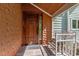 Elegant wooden front door with unique dragonfly knocker and covered porch with seating at 373 & 375 Sagamore Dr, Louisburg, NC 27549