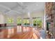 Expansive living room featuring hardwood floors, coffered ceilings, stone fireplace, and sliding glass doors at 373 & 375 Sagamore Dr, Louisburg, NC 27549