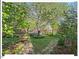 Well-maintained backyard with stone paths, stream with bridge, and mature trees at 4 N Poston Ct, Durham, NC 27705