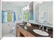 Bathroom with a dual sink vanity and a bright window overlooking a leafy yard at 4 N Poston Ct, Durham, NC 27705
