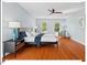 Bright bedroom features hardwood floors, a ceiling fan, and natural light from the windows at 4 N Poston Ct, Durham, NC 27705