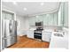 Updated kitchen boasts stainless appliances, white cabinets, and quartz countertops at 4 N Poston Ct, Durham, NC 27705