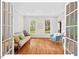 Bright living room with hardwood floors, a futon, and natural light from large windows at 4 N Poston Ct, Durham, NC 27705