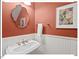Cozy powder room featuring a pedestal sink, wainscoting, and a decorative mirror at 4 N Poston Ct, Durham, NC 27705