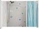 Clean shower featuring white tiling with blue accents and shower curtain at 4 N Poston Ct, Durham, NC 27705