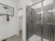 Contemporary shower with glass door and gray tiled walls; a doorway leads to the closet at 404 Gaston Park Ln # 100, Wake Forest, NC 27587