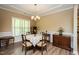 Dining area featuring a chandelier, large window, wood flooring and a table set for a meal at 4057 Mackenzie Dr, Haw River, NC 27258