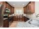 Well-lit kitchen featuring stainless steel appliances, granite countertops, and wood cabinets, offering a modern cooking space at 4057 Mackenzie Dr, Haw River, NC 27258