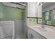 A well-lit bathroom features a shower, mirror, and a sink at 410 Long Ave, Roxboro, NC 27573