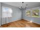 Inviting dining room featuring hardwood floors, natural light from two windows, and a classic chandelier at 410 Long Ave, Roxboro, NC 27573