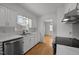 Charming kitchen featuring white cabinets, stainless steel appliances, and wood-look flooring at 410 Long Ave, Roxboro, NC 27573