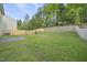 Fenced backyard with retaining wall and lush trees behind at 413 Weeping Willow Dr, Durham, NC 27704