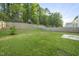 Large fenced backyard with trees and some graded hardscaping at 413 Weeping Willow Dr, Durham, NC 27704