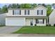 Charming two-story home with a well-maintained lawn and attached two-car garage at 413 Weeping Willow Dr, Durham, NC 27704