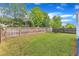 Large, fenced backyard featuring a well-maintained lawn and mature trees, providing privacy and a peaceful setting at 4252 Rockdell Hall St, Raleigh, NC 27616