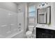 Clean bathroom featuring a shower-tub combo, vanity with dark cabinets, and neutral tile flooring at 4252 Rockdell Hall St, Raleigh, NC 27616