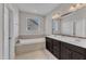 Ensuite bathroom features a double sink vanity, mirror, and soaking tub under a window at 4252 Rockdell Hall St, Raleigh, NC 27616