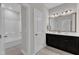 Modern bathroom with a double sink vanity and tub at 4252 Rockdell Hall St, Raleigh, NC 27616