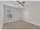 A cozy bedroom features neutral paint, carpet, ceiling fan, and natural light from a window at 4252 Rockdell Hall St, Raleigh, NC 27616
