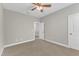 This bedroom is carpeted, features a ceiling fan, and a door to another room at 4252 Rockdell Hall St, Raleigh, NC 27616