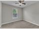 Cozy bedroom with neutral carpet, ceiling fan, and window providing natural light at 4252 Rockdell Hall St, Raleigh, NC 27616
