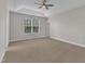 Neutral bedroom with carpet, a tray ceiling with fan, and natural light at 4252 Rockdell Hall St, Raleigh, NC 27616