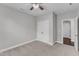 Spacious bedroom with carpet, ceiling fan, closet and view of a hallway and door at 4252 Rockdell Hall St, Raleigh, NC 27616
