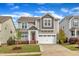 Charming two-story home with a well-manicured lawn, attached garage, and a welcoming front porch at 4252 Rockdell Hall St, Raleigh, NC 27616