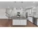 Kitchen with granite island, stainless appliances, white cabinets and hardwood floors at 4252 Rockdell Hall St, Raleigh, NC 27616
