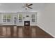 Bright living room featuring a fireplace, dark hardwood floors, and several windows at 4252 Rockdell Hall St, Raleigh, NC 27616